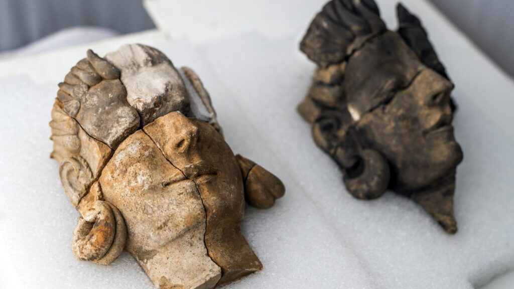 Dos cabezas escultóricas de terracota fracturadas, halladas en una excavación arqueológica.