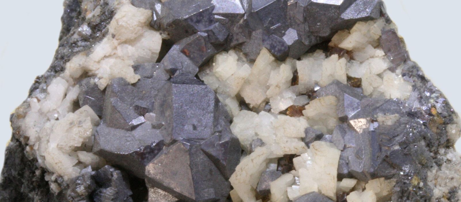 Cristales de galena, mineral del que se extrae el plomo, de color gris metálico, junto a cristales blancos de dolomita, de la mina de Áliva (Cantabria)